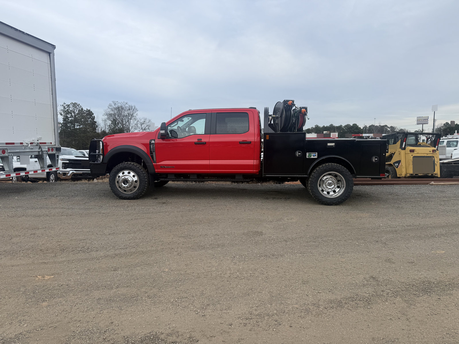 Side view of a red crew-cab pickup with a black service body