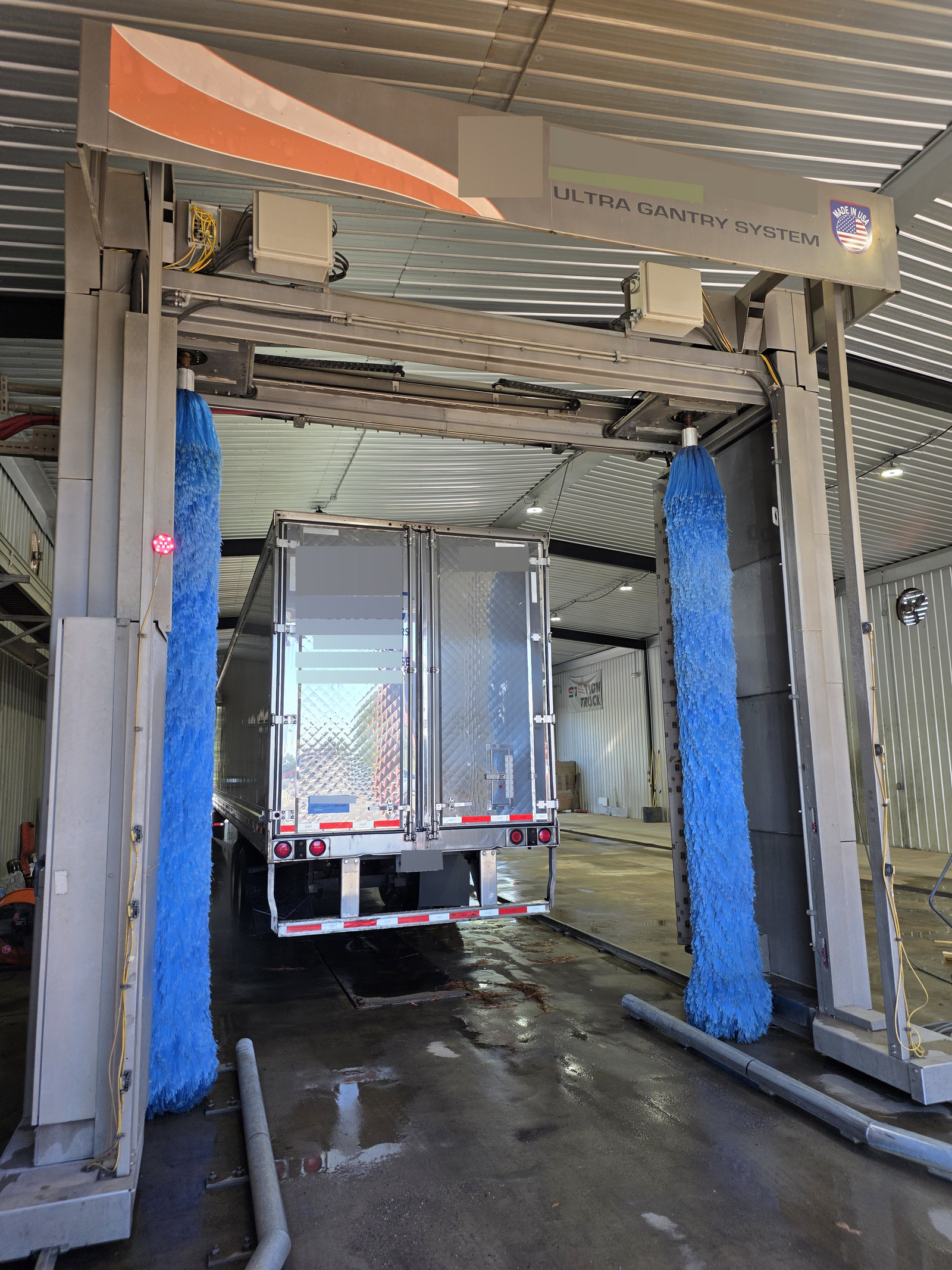Rear of a trailer between blue wash brushes