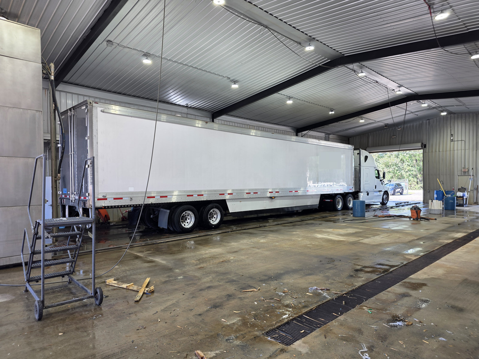 Side view of a tractor-trailer inside the wash bay